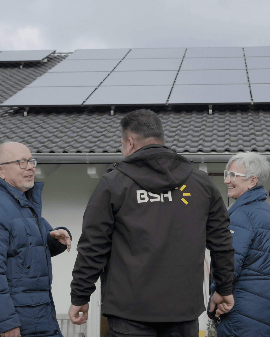 Kunden blicken mit Fachberater auf ihre Photovoltaikanlage