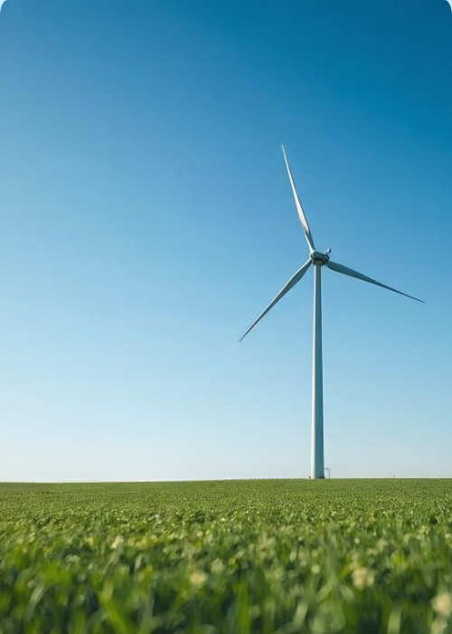 Moderne Windkraftanlage auf einem grünen Feld unter blauem Himmel – Symbol für erneuerbare Energien und nachhaltige Stromerzeugung