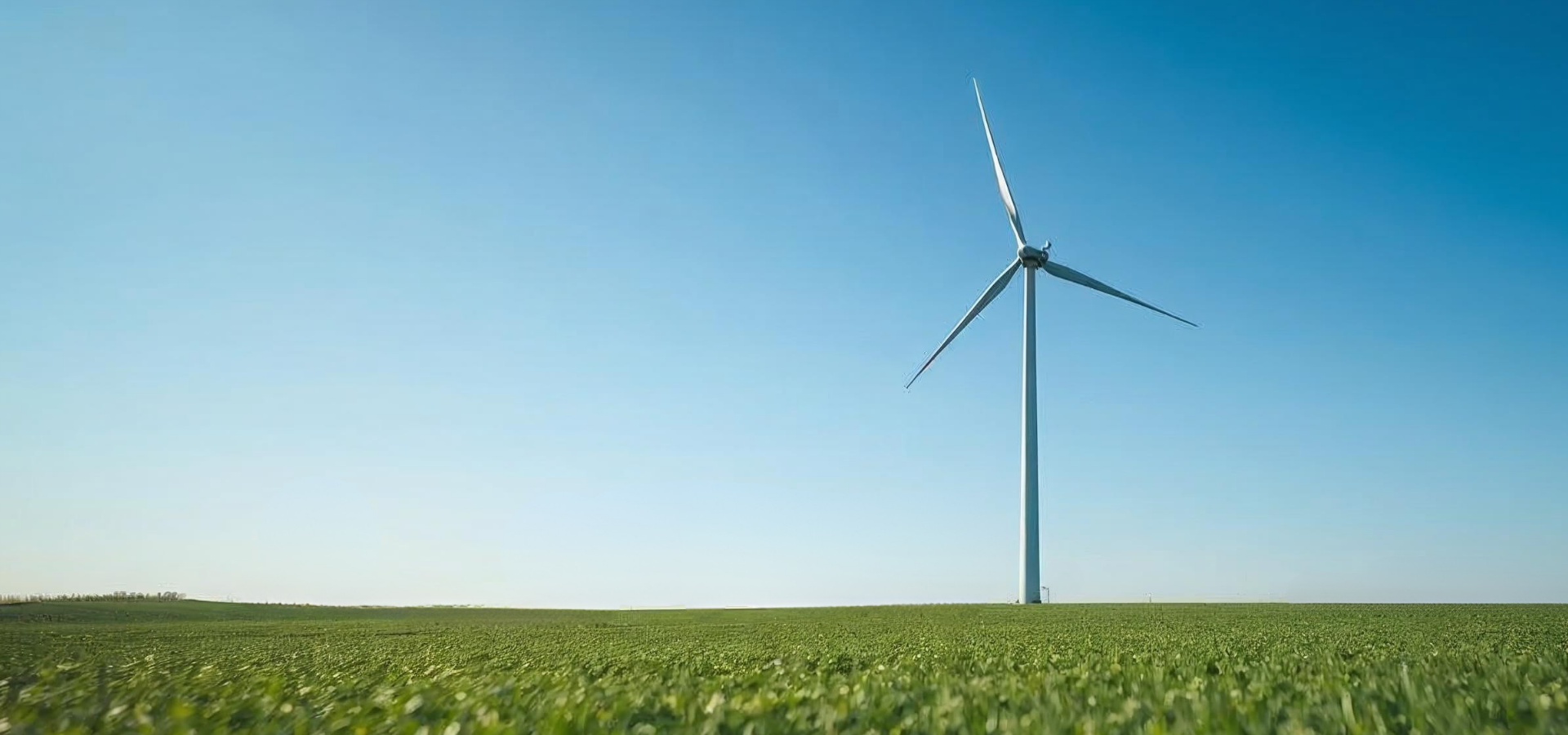Moderne Windkraftanlage auf einem grünen Feld unter blauem Himmel – Symbol für erneuerbare Energien und nachhaltige Stromerzeugung