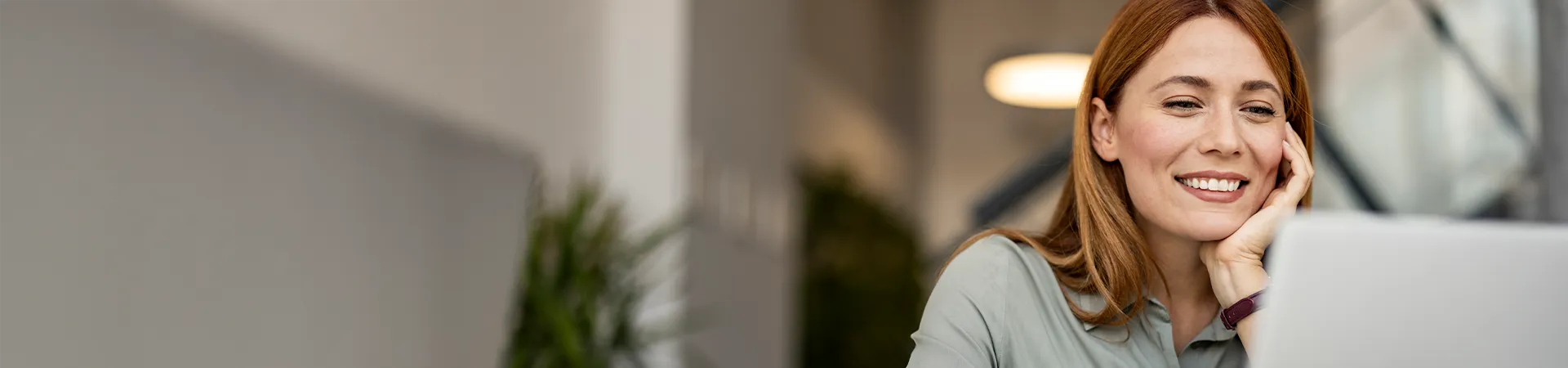 Frau recherchiert am Laptop zu Photovoltaik-Finanzierungen für Unternehmen