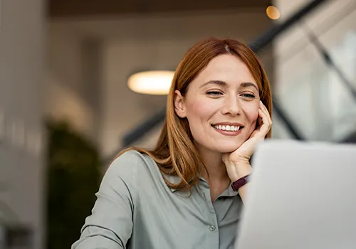Frau recherchiert am Laptop zu Photovoltaik-Finanzierungen für Unternehmen