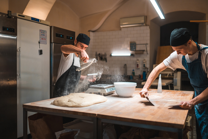 Bäcker bei der Arbeit in der Backstube – hoher Energiebedarf durch Öfen und Kühltechnik