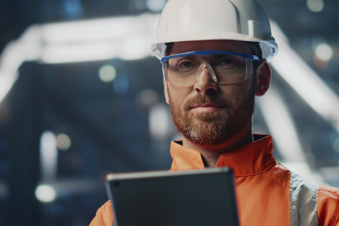 Unternehmensleiter mit Schutzhelm und Tablet informiert sich über Energieprojekte von BSH